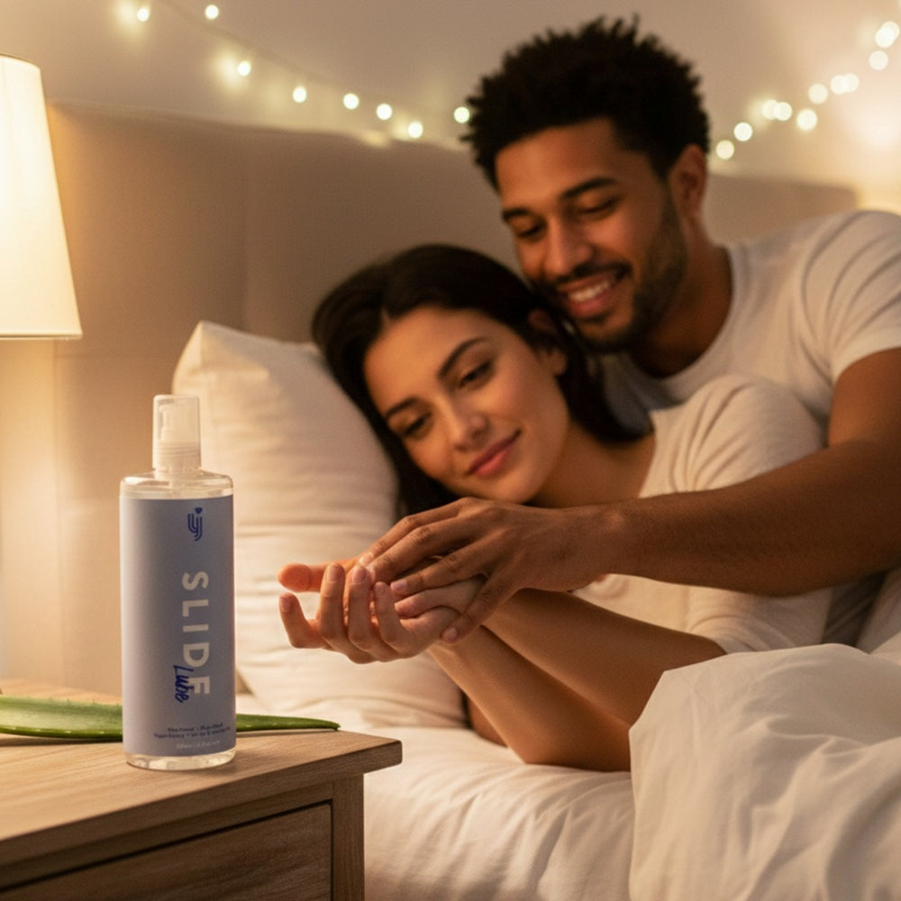 Loving Joy Slide water-based lubricant 500ml bottle displayed in a lifestyle setting with soft lighting.